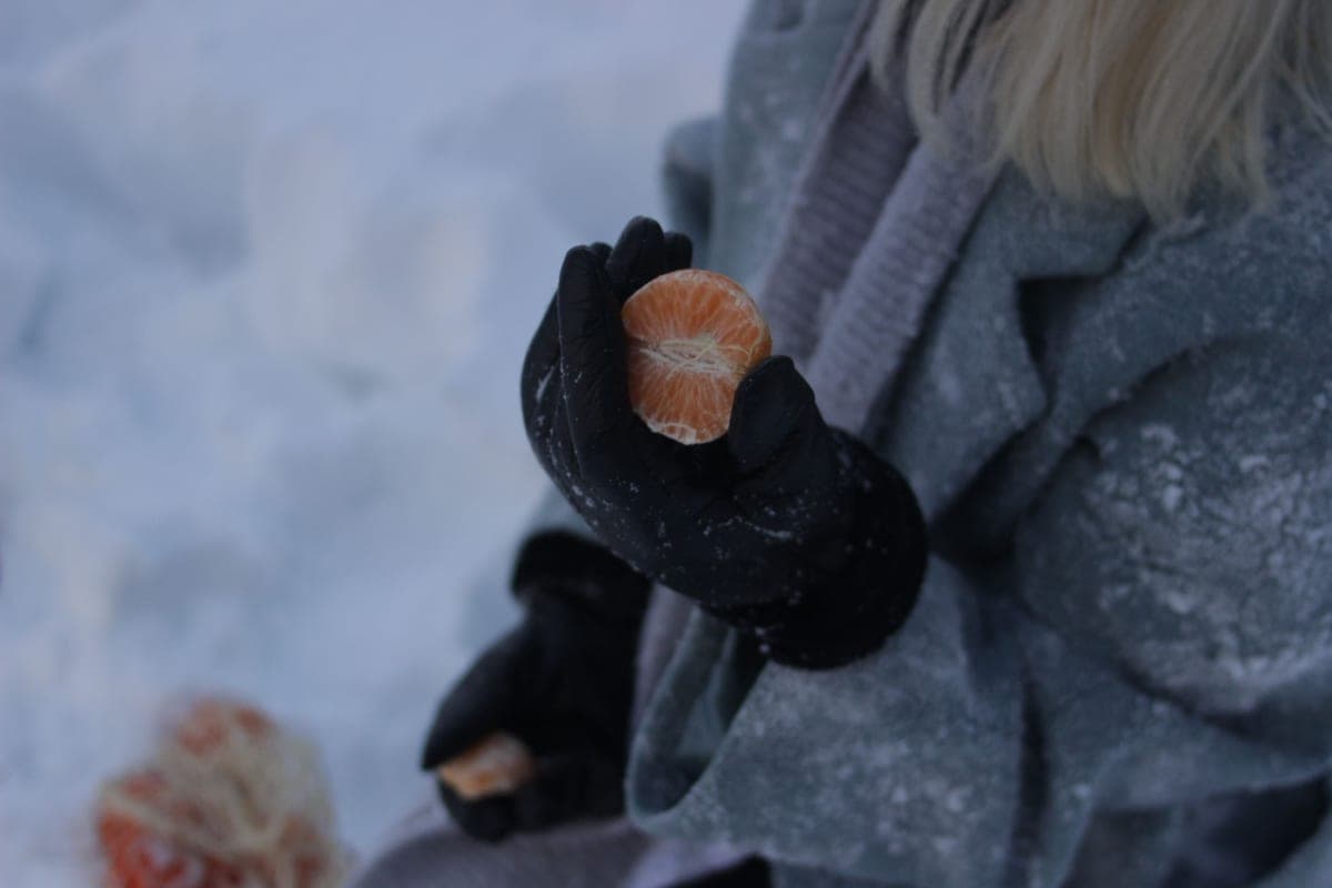 A close-up of gloved hands outdoors in winter